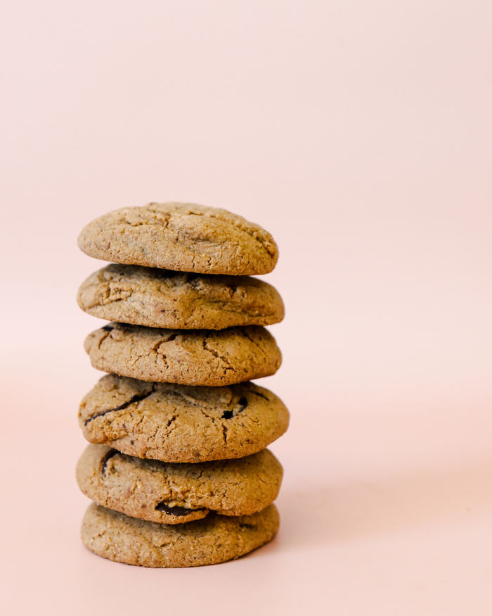 Crumble Charms chocolate chip gluten-free vegan cookies on pink background